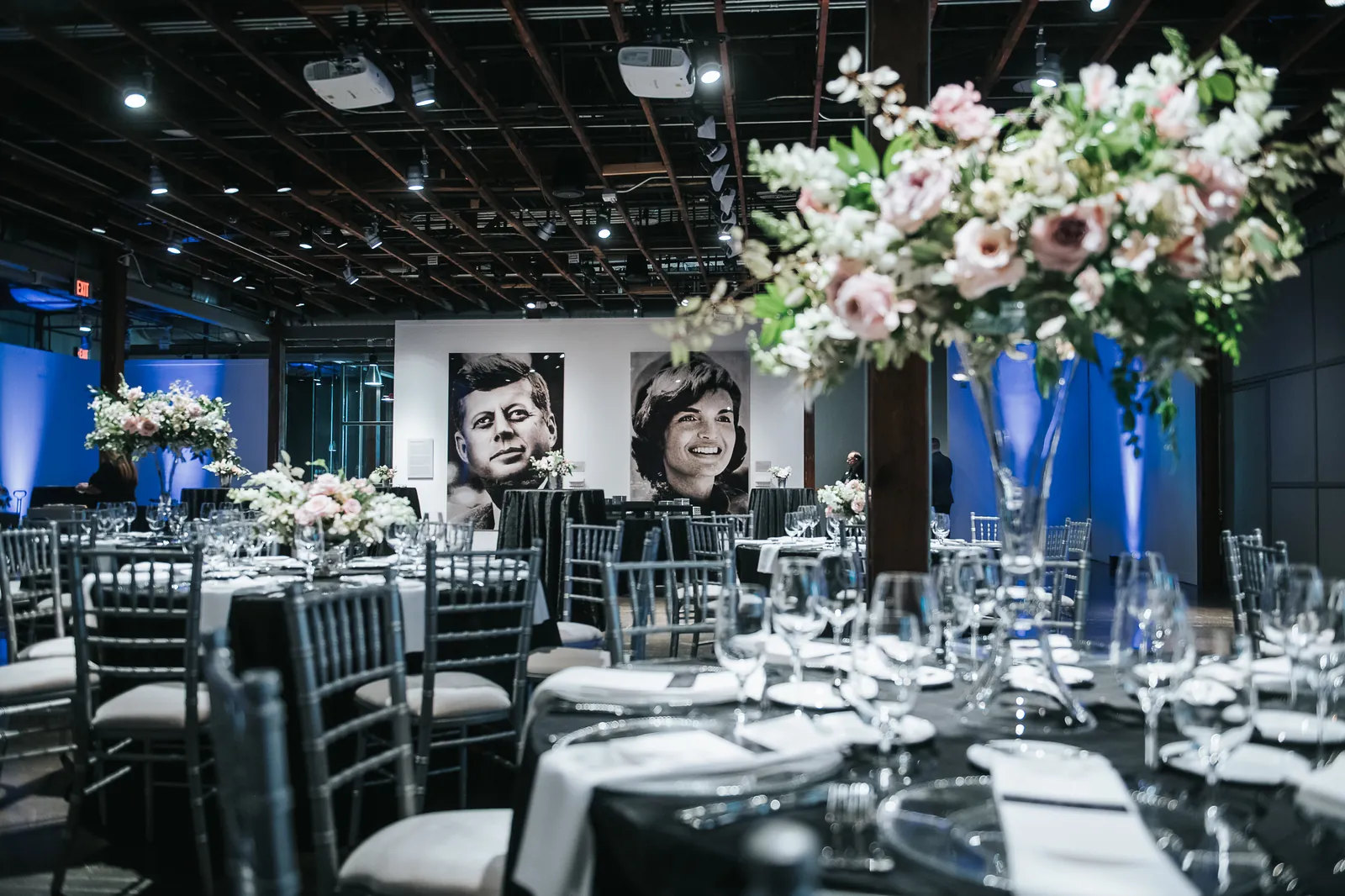 A banquet room set with tall floral centrepieces